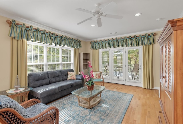 living room featuring light hardwood / wood-style flooring, ornamental molding, and ceiling fan