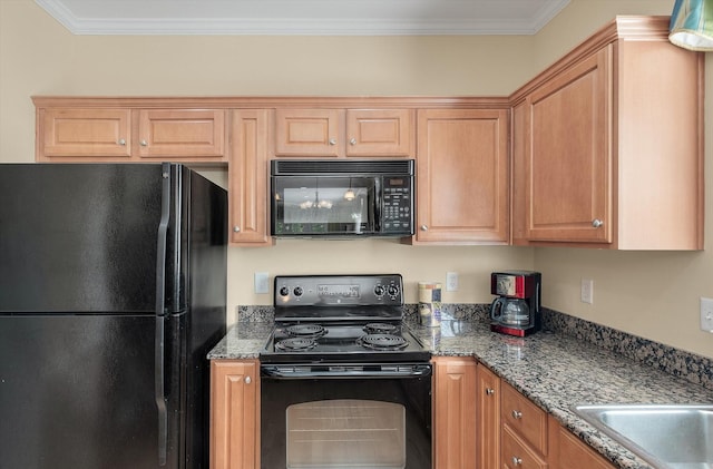 kitchen with black appliances, crown molding, and dark stone counters