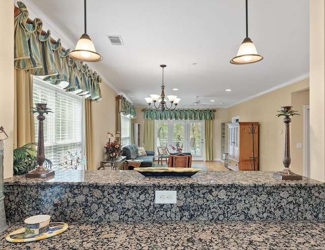 kitchen with ornamental molding, decorative light fixtures, and ceiling fan with notable chandelier