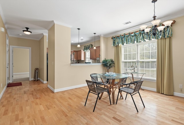 dining area featuring crown molding, a notable chandelier, and light hardwood / wood-style floors