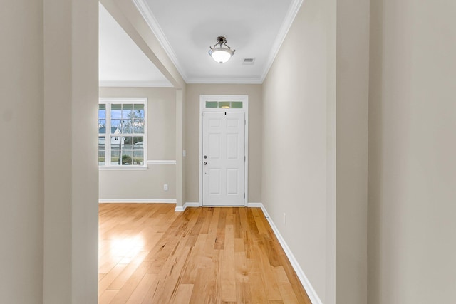 entryway with light wood-type flooring, visible vents, crown molding, and baseboards