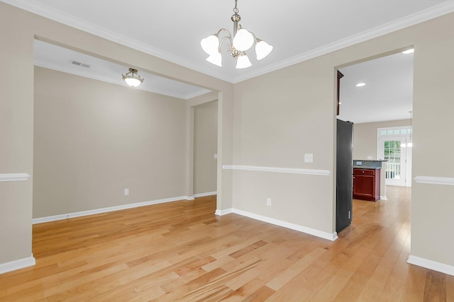 empty room with light wood finished floors, baseboards, a chandelier, and ornamental molding