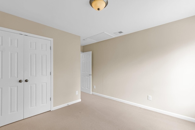 unfurnished bedroom with light colored carpet, a closet, visible vents, and baseboards