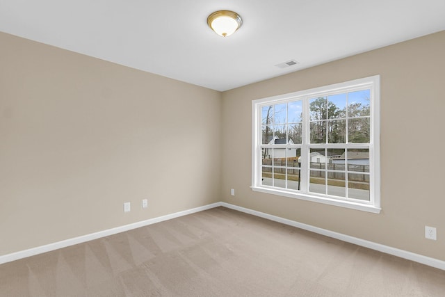 carpeted empty room featuring visible vents and baseboards