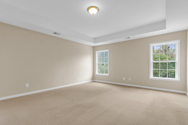 spare room with visible vents, light carpet, and baseboards