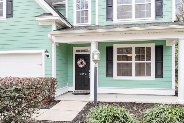 property entrance featuring a garage and a shingled roof