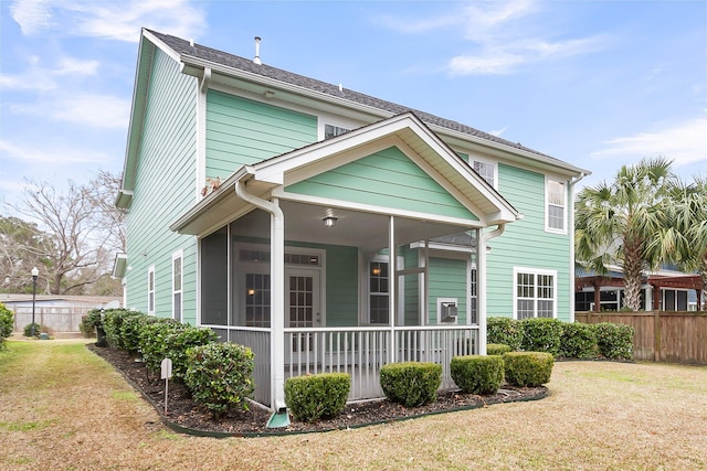 exterior space featuring a sunroom, fence, and a front yard