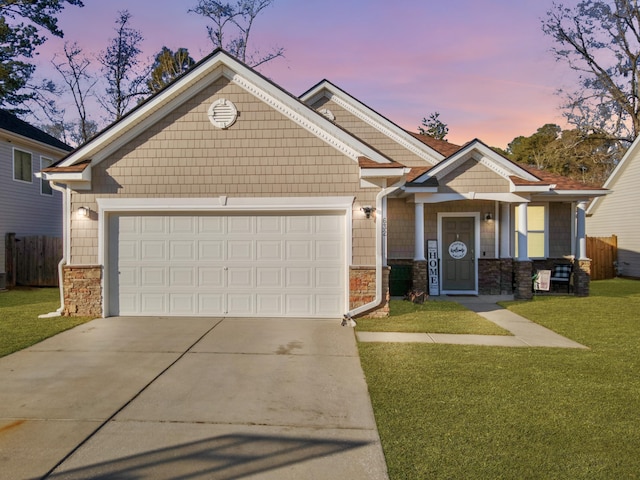 craftsman-style house featuring a garage and a lawn