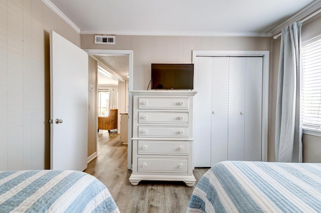 1400 Ocean Blvd Unit 106B, Isle Of Palms, SC 29451 - bedroom featuring ornamental molding, light wood-style floors, a closet, and wooden walls