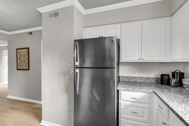 2362 Parsonage Rd Unit 2H, Charleston, SC 29414 - kitchen featuring freestanding refrigerator, ornamental molding, light wood finished floors, white cabinets, and light stone countertops
