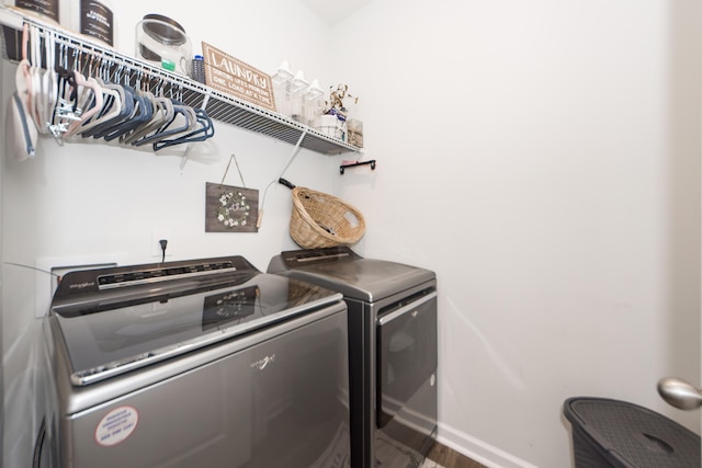 washroom with hardwood / wood-style flooring and washer and clothes dryer