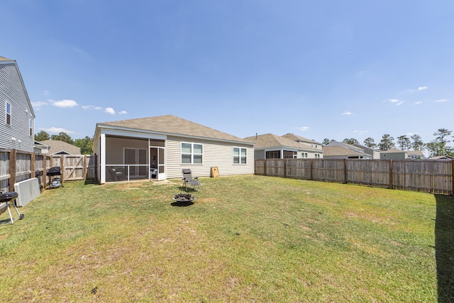 rear view of property featuring a sunroom and a lawn