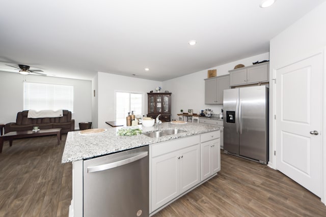 kitchen featuring a kitchen island with sink, dark hardwood / wood-style flooring, stainless steel appliances, sink, and ceiling fan