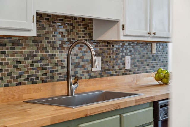 1027 Wayfarer Ln, Charleston, SC 29412 - kitchen view of butcher block countertops, a sink, backsplash, and white cabinets