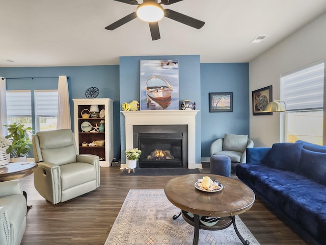 living room featuring dark wood-type flooring and ceiling fan