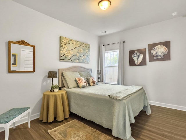 bedroom with dark hardwood / wood-style floors