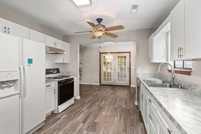 kitchen featuring under cabinet range hood, white refrigerator with ice dispenser, a sink, white cabinets, and range with gas stovetop