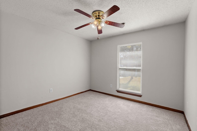 unfurnished room featuring carpet floors, ceiling fan, baseboards, and a textured ceiling