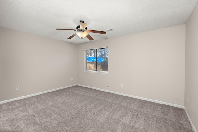 empty room featuring carpet, visible vents, baseboards, and a textured ceiling