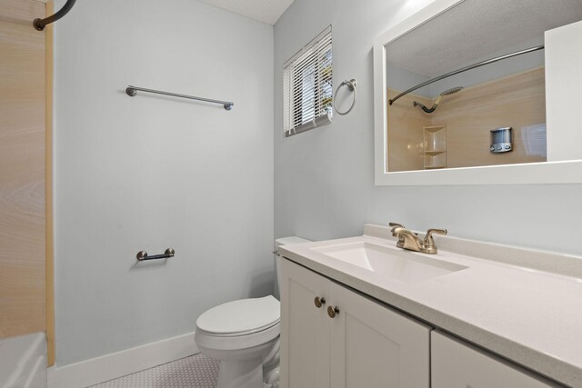 bathroom with a shower, toilet, vanity, baseboards, and tile patterned floors