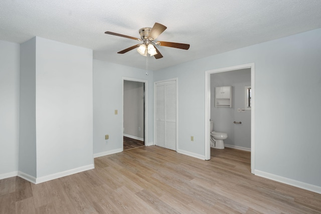 unfurnished bedroom with light wood finished floors, baseboards, and a textured ceiling