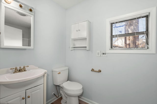 bathroom featuring vanity, toilet, and baseboards