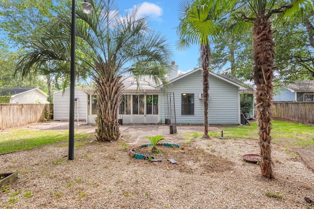 back of house featuring a chimney, a patio area, and a fenced backyard