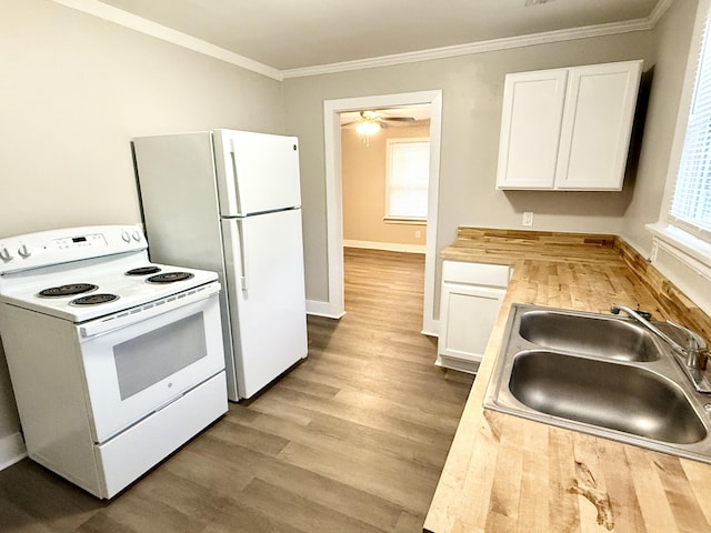 307 Mill St, Walterboro, SC 29488 - kitchen with a sink, white appliances, crown molding, light wood finished floors, and white cabinets