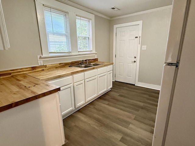 307 Mill St, Walterboro, SC 29488 - kitchen featuring a sink, white cabinetry, dark wood-type flooring, butcher block countertops, and ornamental molding