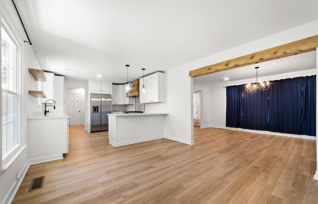 kitchen with hanging light fixtures, light wood-type flooring, a notable chandelier, white cabinetry, and stainless steel fridge with ice dispenser