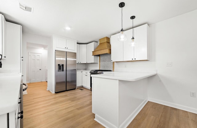 kitchen with white cabinets, appliances with stainless steel finishes, light hardwood / wood-style floors, and custom exhaust hood