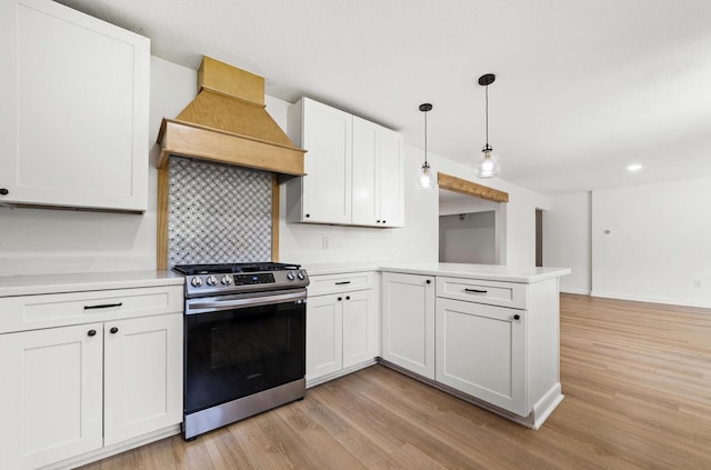 kitchen featuring white cabinetry, hanging light fixtures, light wood-type flooring, stainless steel stove, and custom exhaust hood