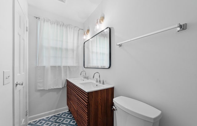 bathroom with vanity, toilet, and a wealth of natural light