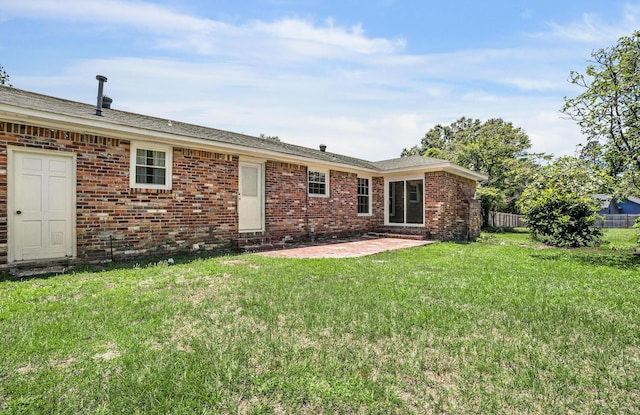 back of property with a yard and a patio