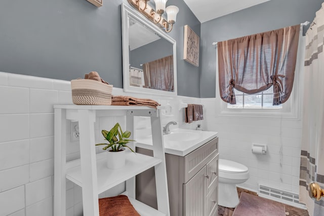 bathroom with tile walls, vanity, and toilet