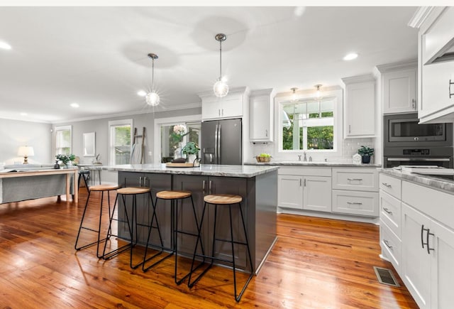1211 Dennis Blvd, Moncks Corner, SC 29461 - kitchen with stainless steel appliances, a breakfast bar area, ornamental molding, a kitchen island, and healthy amount of natural light