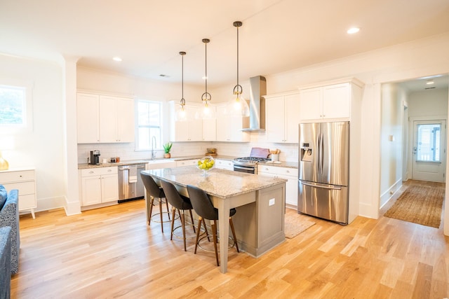 3707 Gambrill Ln, Mount Pleasant, SC 29466 - kitchen with appliances with stainless steel finishes, wall chimney exhaust hood, a center island, tasteful backsplash, and a breakfast bar