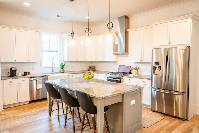 3707 Gambrill Ln, Mount Pleasant, SC 29466 - kitchen with stainless steel appliances, wall chimney range hood, a sink, a center island, and light wood-style flooring