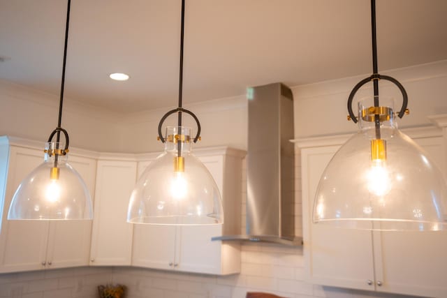 3707 Gambrill Ln, Mount Pleasant, SC 29466 - kitchen view of a chandelier, wall chimney range hood, hanging light fixtures, white cabinets, and ornamental molding
