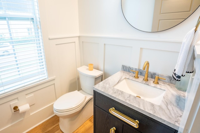 3707 Gambrill Ln, Mount Pleasant, SC 29466 - half bathroom with a decorative wall, vanity, toilet, wood finished floors, and wainscoting