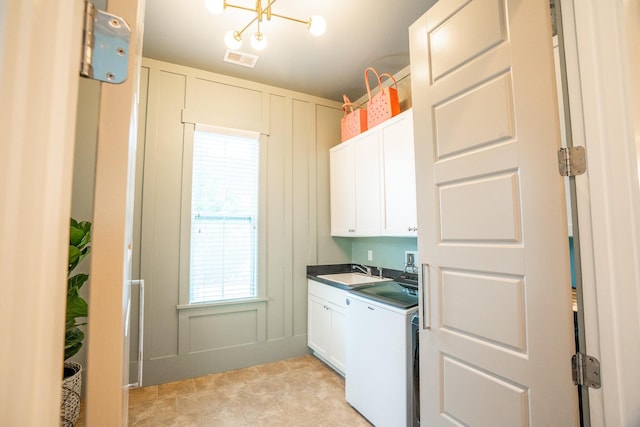 3707 Gambrill Ln, Mount Pleasant, SC 29466 - laundry area with cabinet space, washer / dryer, plenty of natural light, a decorative wall, and a chandelier
