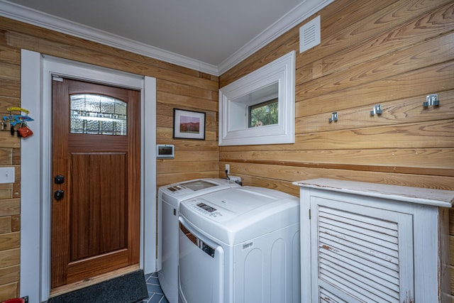 clothes washing area featuring laundry area, wooden walls, crown molding, and independent washer and dryer