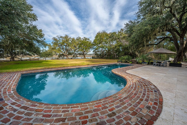 pool with a patio area and a yard