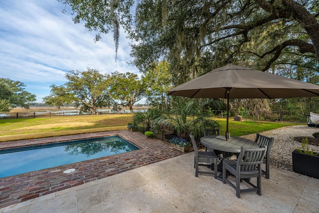 view of swimming pool featuring a patio, outdoor dining area, a fenced backyard, a yard, and a fenced in pool