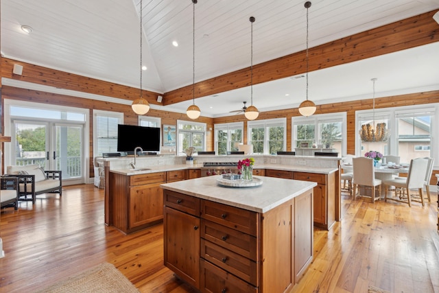 kitchen with brown cabinets, a large island with sink, light wood-style flooring, and open floor plan