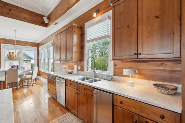 kitchen with brown cabinetry, a sink, light wood-style flooring, and dishwasher