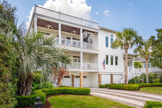 view of front of property with a garage, ceiling fan, a balcony, stairs, and concrete driveway