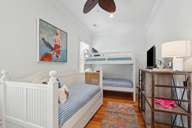 bedroom with crown molding, wood finished floors, and visible vents