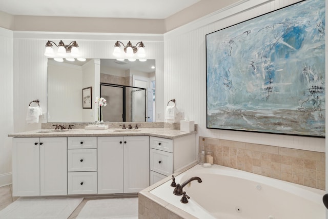 full bath featuring a sink, a jetted tub, a stall shower, and double vanity