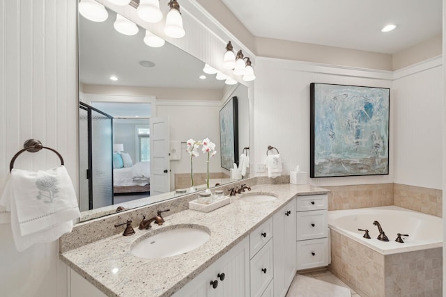 bathroom with double vanity, a sink, connected bathroom, and a garden tub